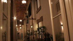 Un pasillo con suelo a cuadros, techo de ladrillo y luces en la pared.