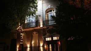Un edificio con balcón y detalles arquitectónicos ornamentados.