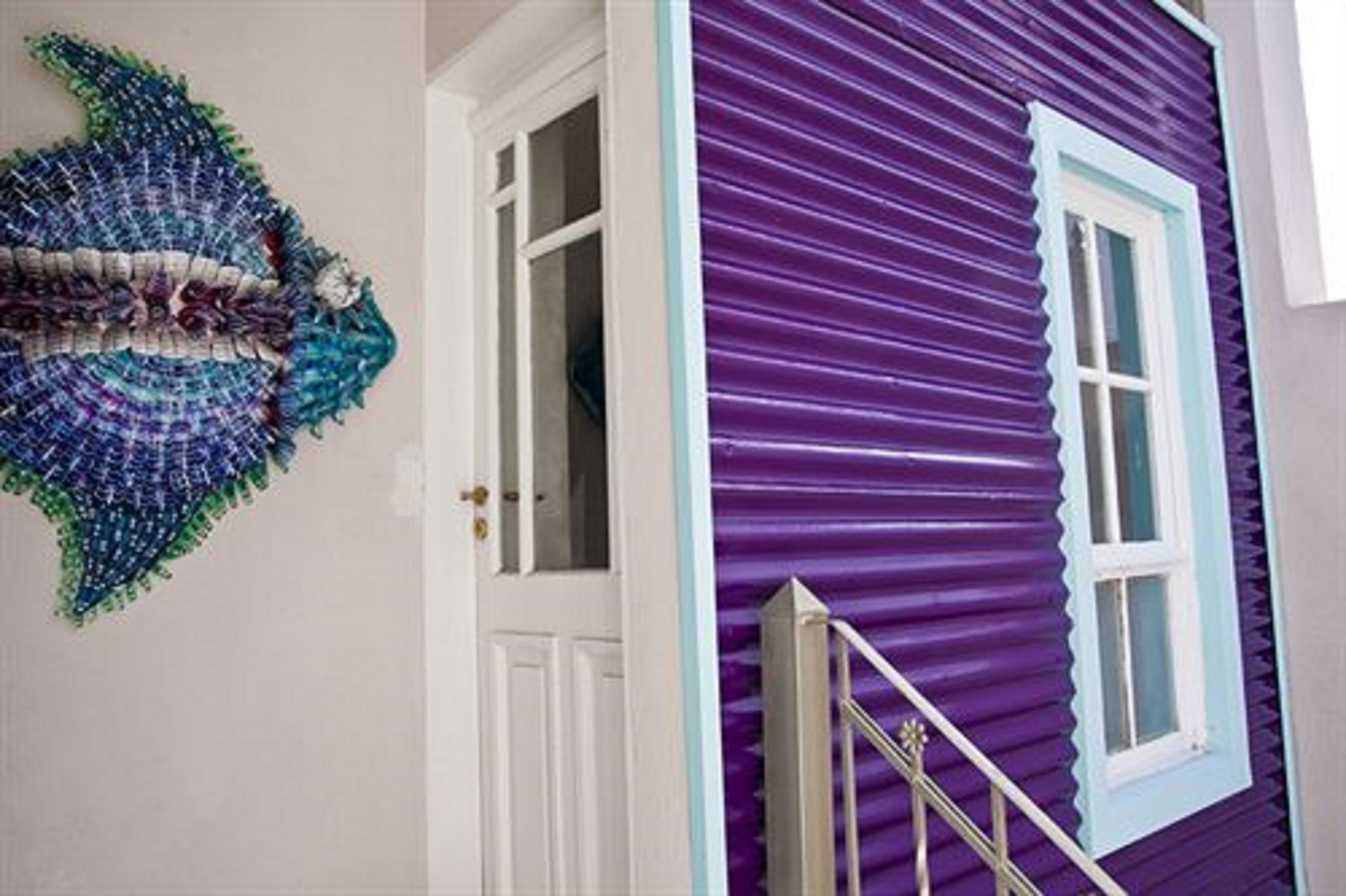 A purple house with a white door and a staircase.