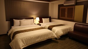 A hotel room with two beds, a wooden headboard, a brown leather couch, and an air conditioning unit on the wall. - Hill house Hotel (Seoul)