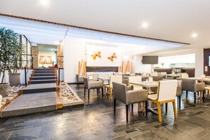 A modern hotel lobby with a staircase, seating area, and a flat-screen TV. - Hill house Hotel (Seoul)