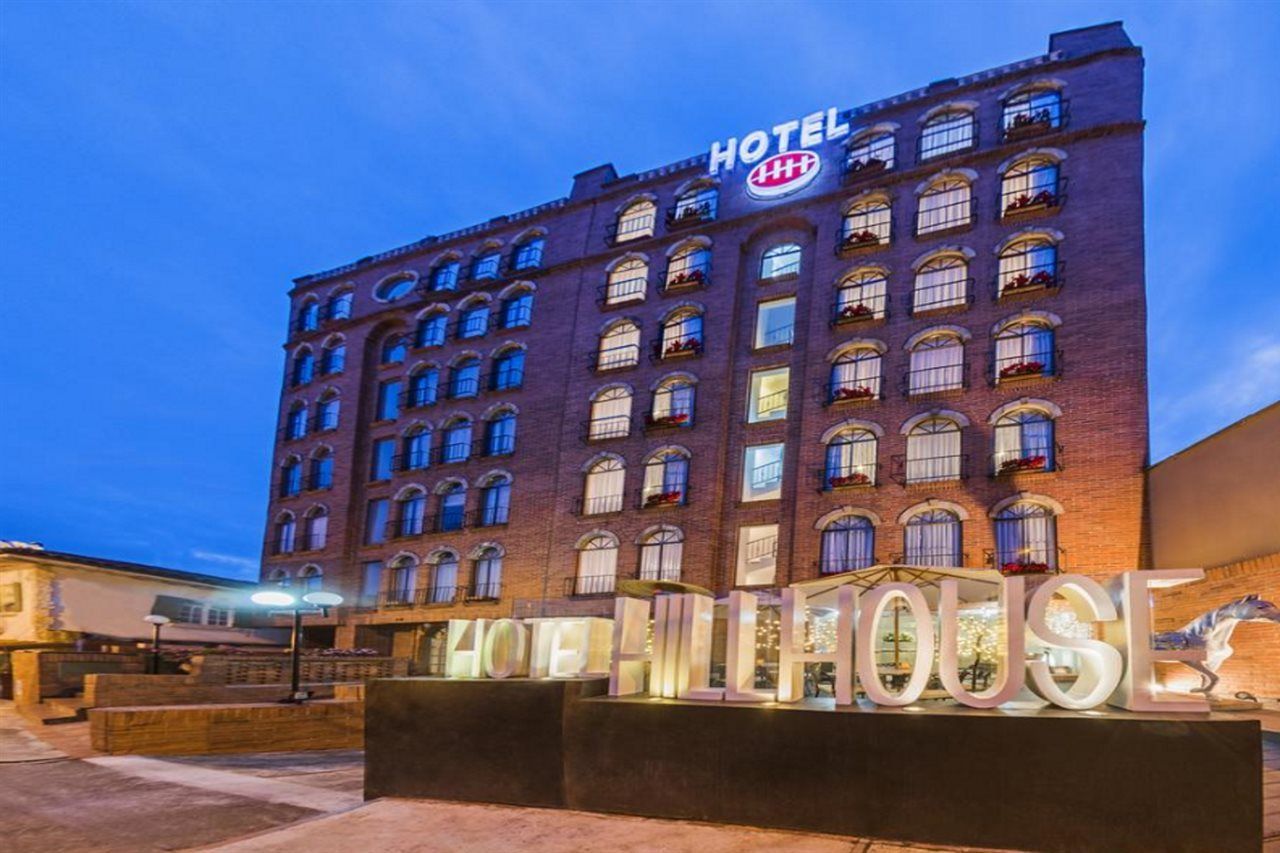 A hotel with a prominent sign reading 'HOTEL' and 'HOTEL HOUSE' in illuminated letters.