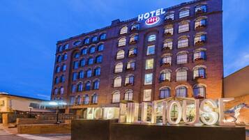 A hotel with a prominent sign reading 'HOTEL' and 'HOTEL HOUSE' in illuminated letters.