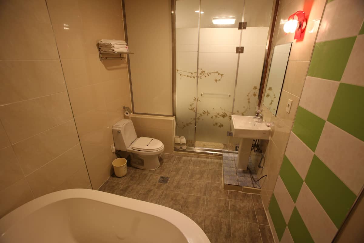 Un baño con bañera, inodoro y zona de ducha.