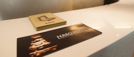 A hotel reception desk with a brochure and a sign.