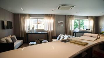 Una habitación de hotel con una cama grande, un escritorio, un televisor y una ventana con cortinas.