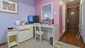 Una habitación con escritorio, silla, televisor y espejo.
