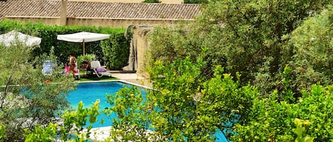 Una piscina al aire libre de temporada, sombrillas