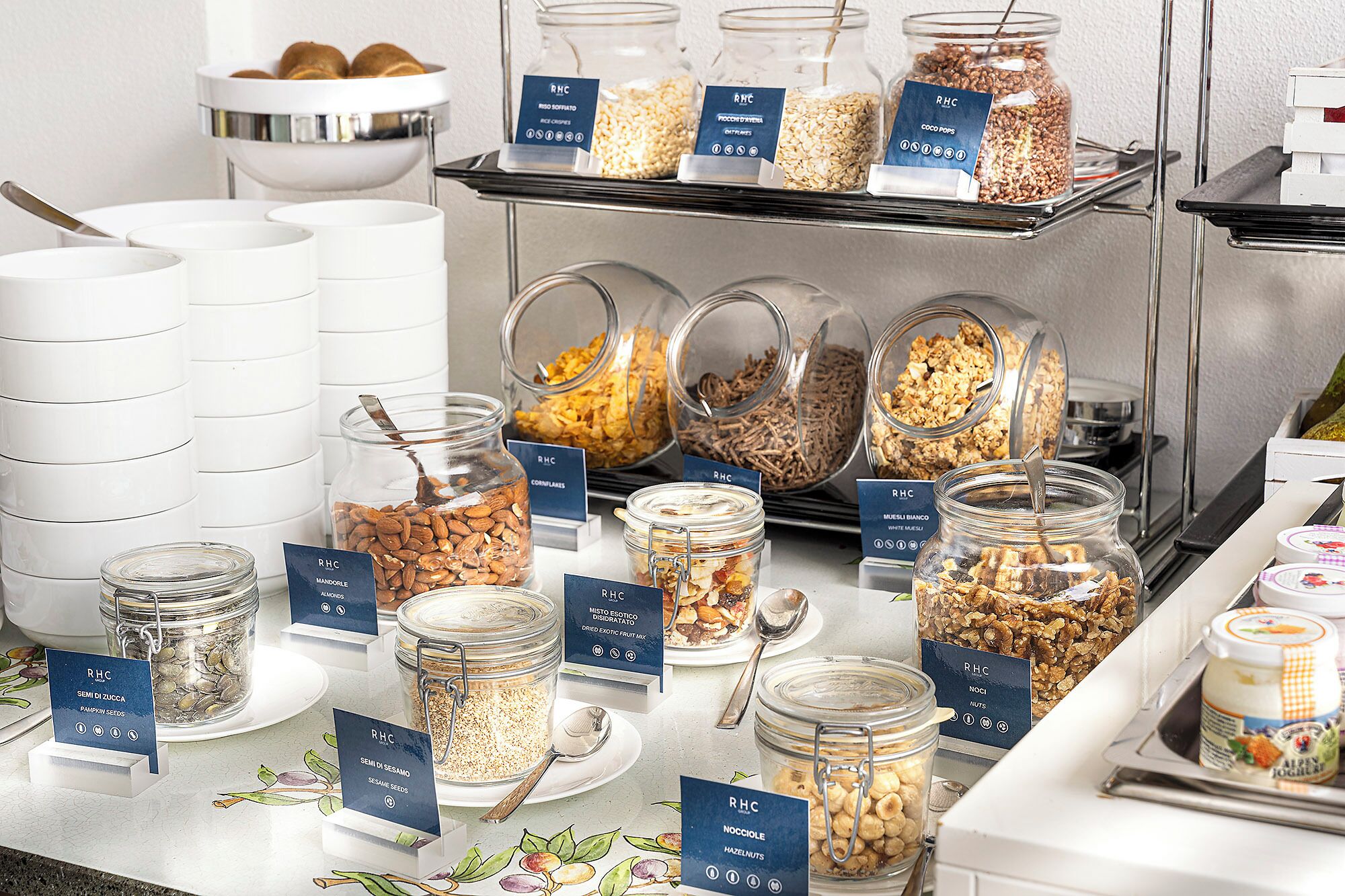 A buffet with various food items in jars and bowls, each labeled with the RHC logo.