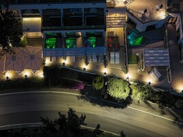 Un hotel moderno con asientos al aire libre, un área techada y una piscina.