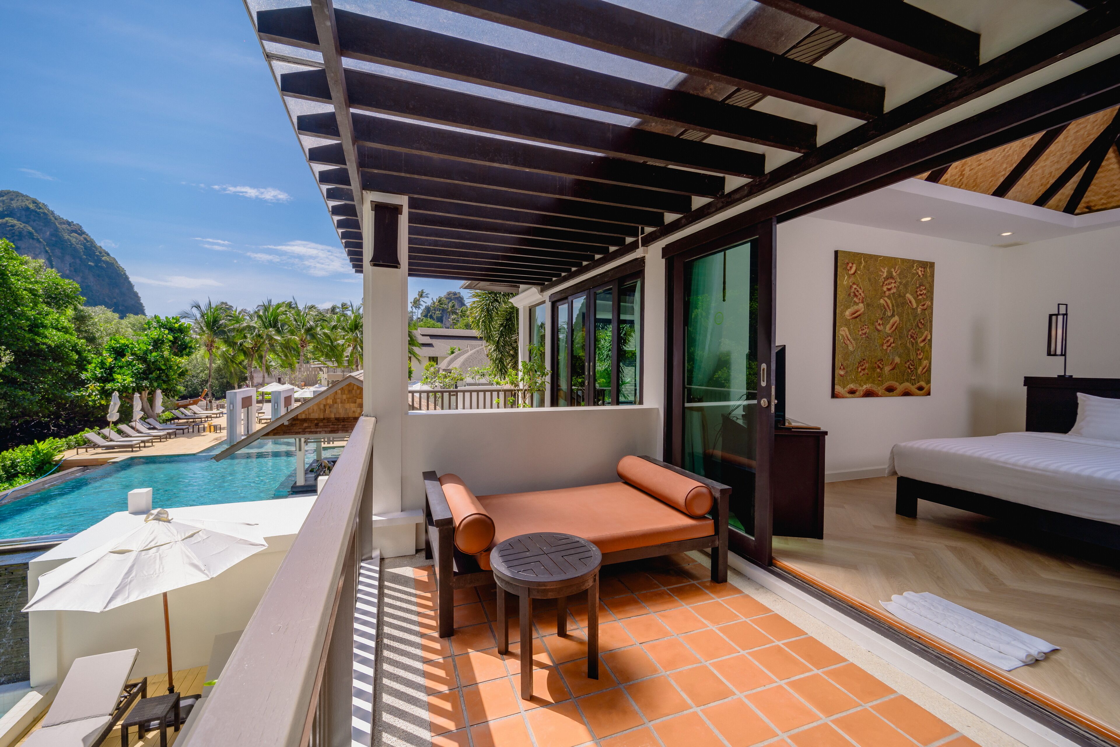 Un balcon avec une piscine, une chaise longue et un lit.