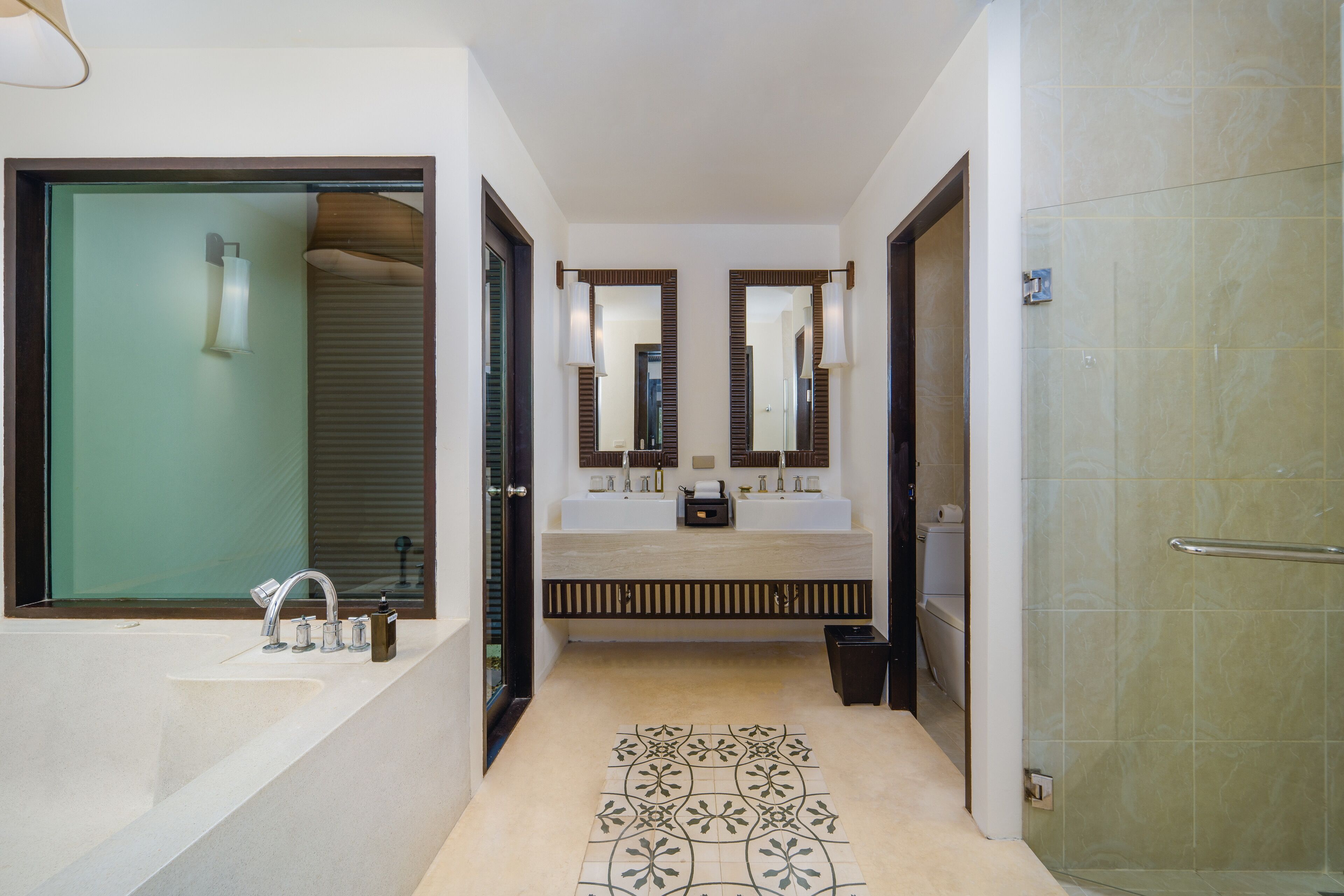 A modern bathroom with a large sink, two mirrors, and a shower area.