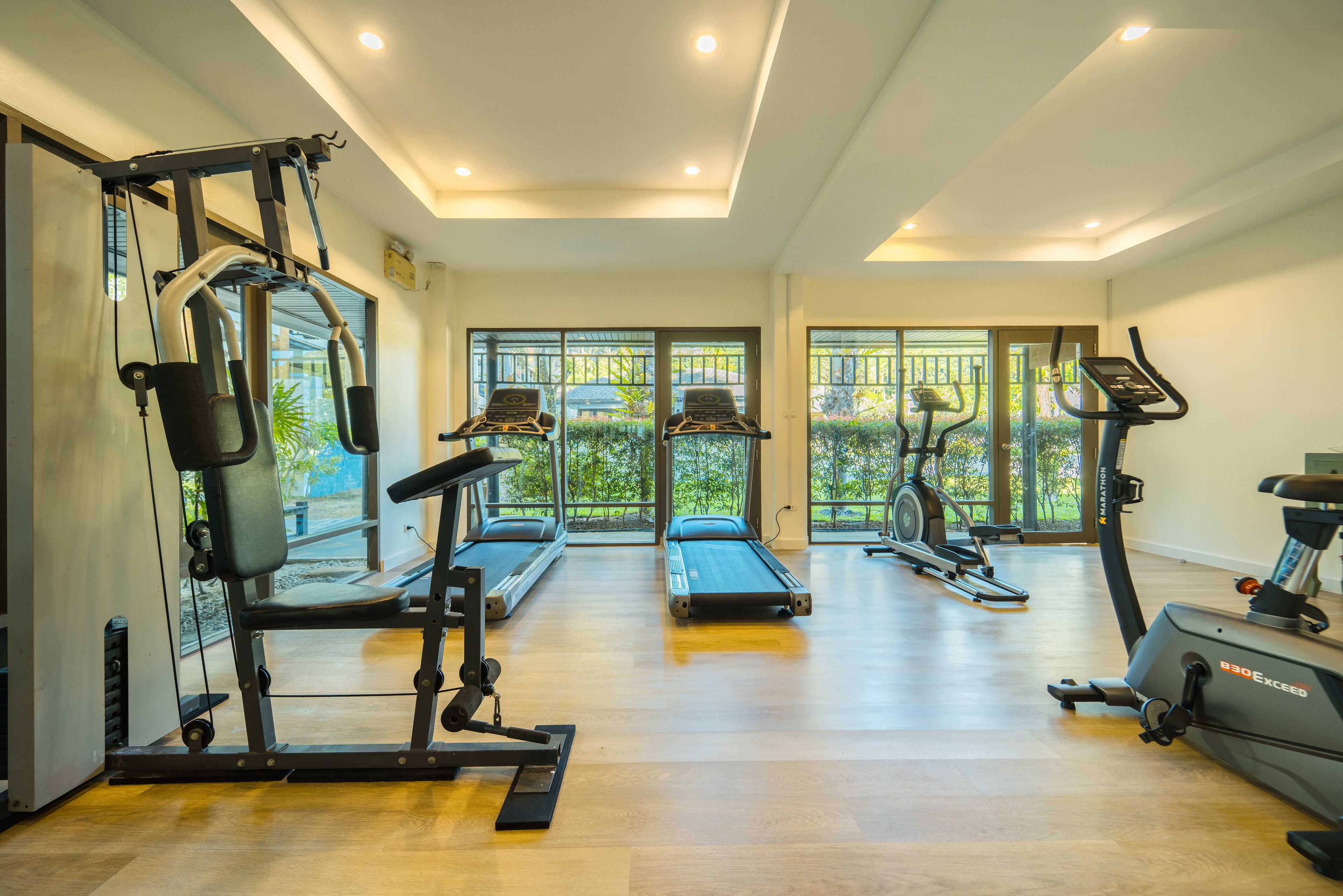 A gym with cardio machines, weightlifting equipment, and a treadmill.