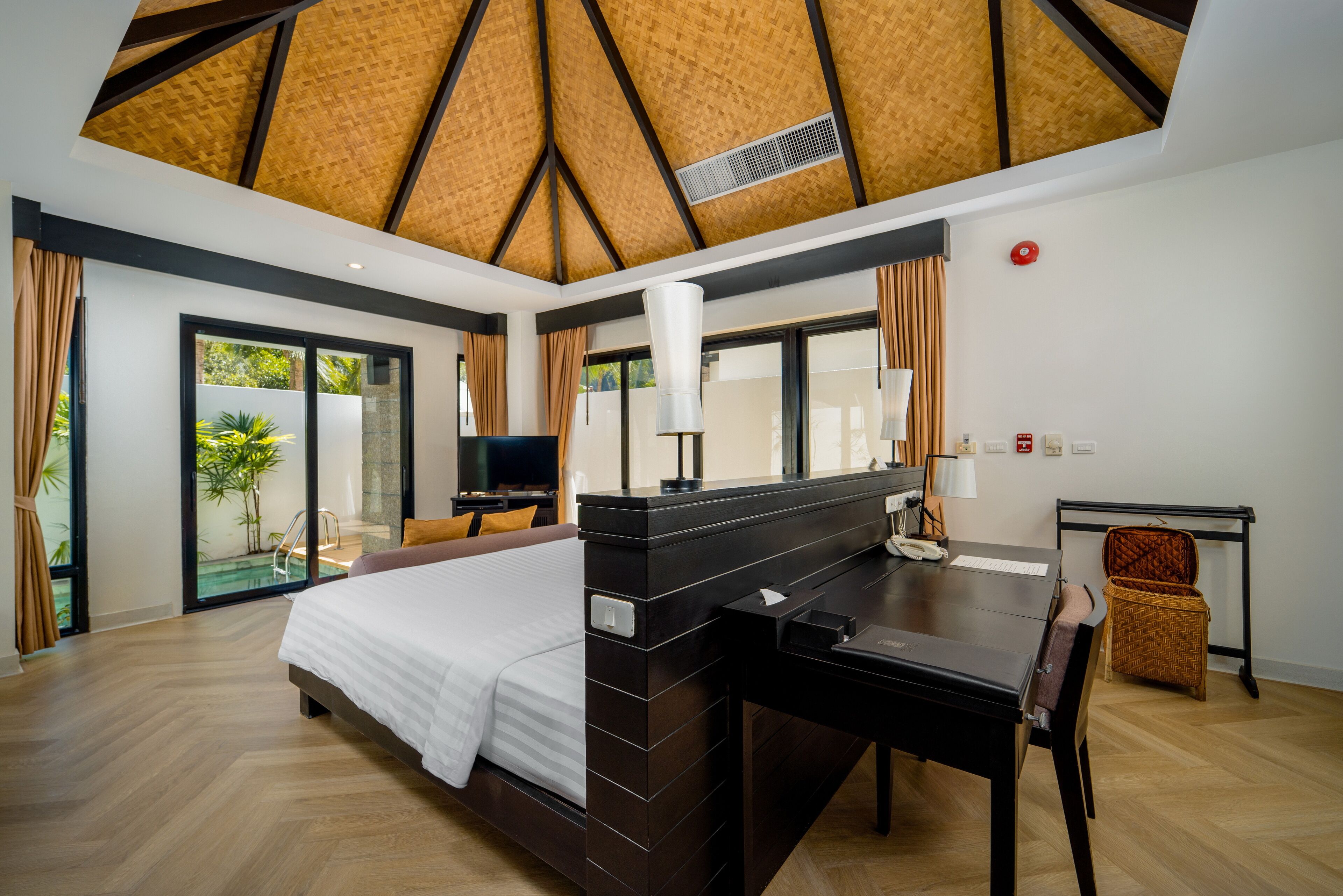 A modern hotel room with a large bed, a desk, and a television.