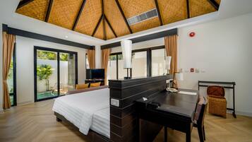 A modern hotel room with a large bed, a desk, and a television.