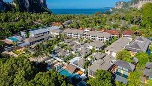 Een resort met meerdere gebouwen, een zwembad en uitzicht op de oceaan en kliffen.