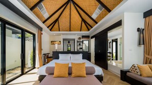 Een moderne slaapkamer met een groot bed, een bankje en uitzicht op het omliggende landschap.