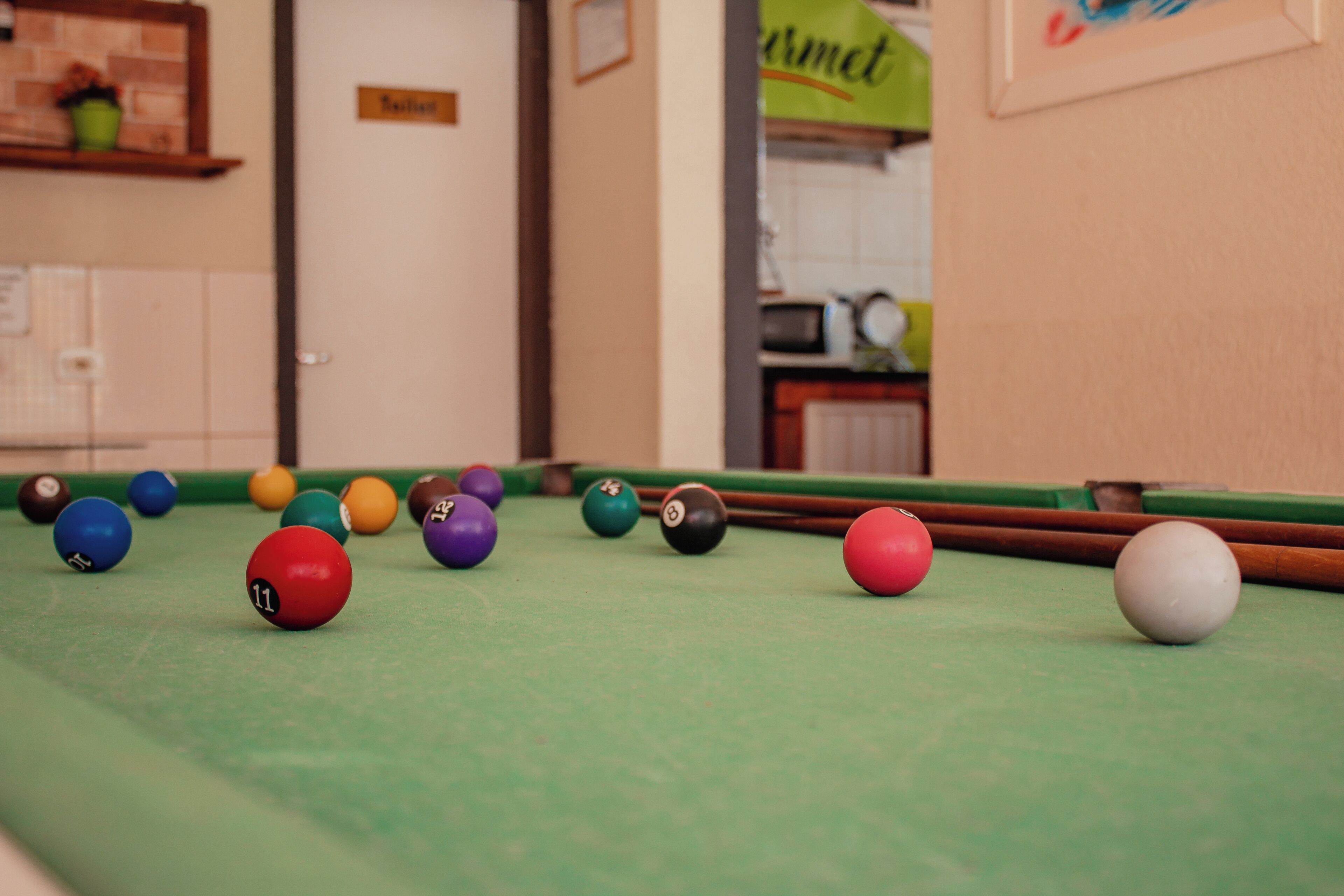 Une table de billard avec des billes de différentes couleurs et un queue de billard.