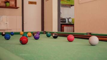 Une table de billard avec des billes de différentes couleurs et un queue de billard.