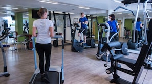 A gym with treadmills, elliptical machines, and weight equipment. - Hotel Bayern Vital (Bad Reichenhall)