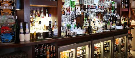 A bar area with shelves stocked with various liquor bottles and glasses.