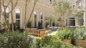 An outdoor seating area with wooden furniture and planters.