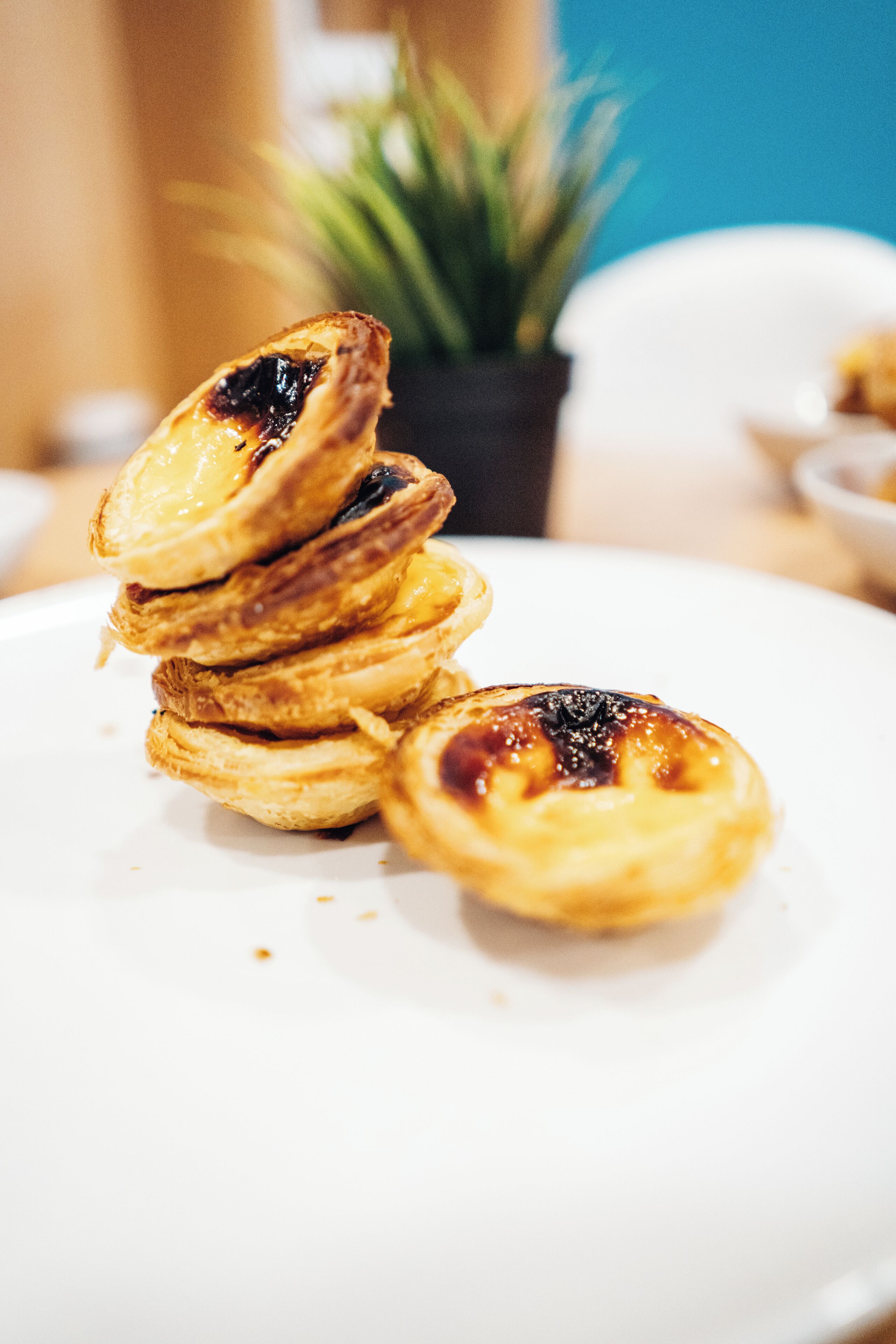 Una torre de pasteles portugueses de crema en un plato blanco.