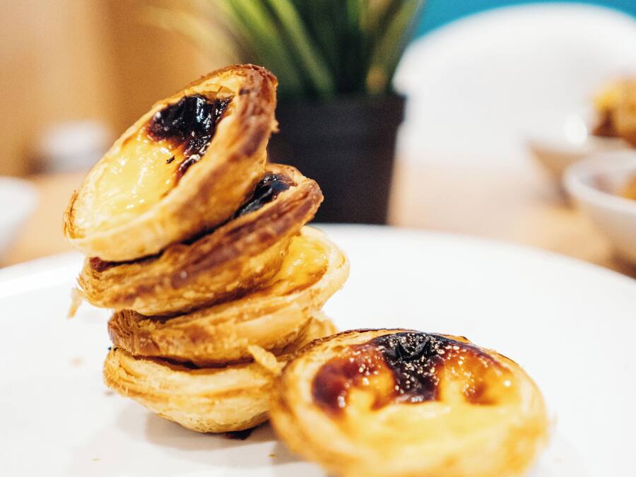 Una torre de pasteles portugueses de crema en un plato blanco.