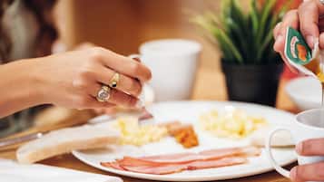 Un desayuno con huevos, tocino, tostadas y una taza de café.