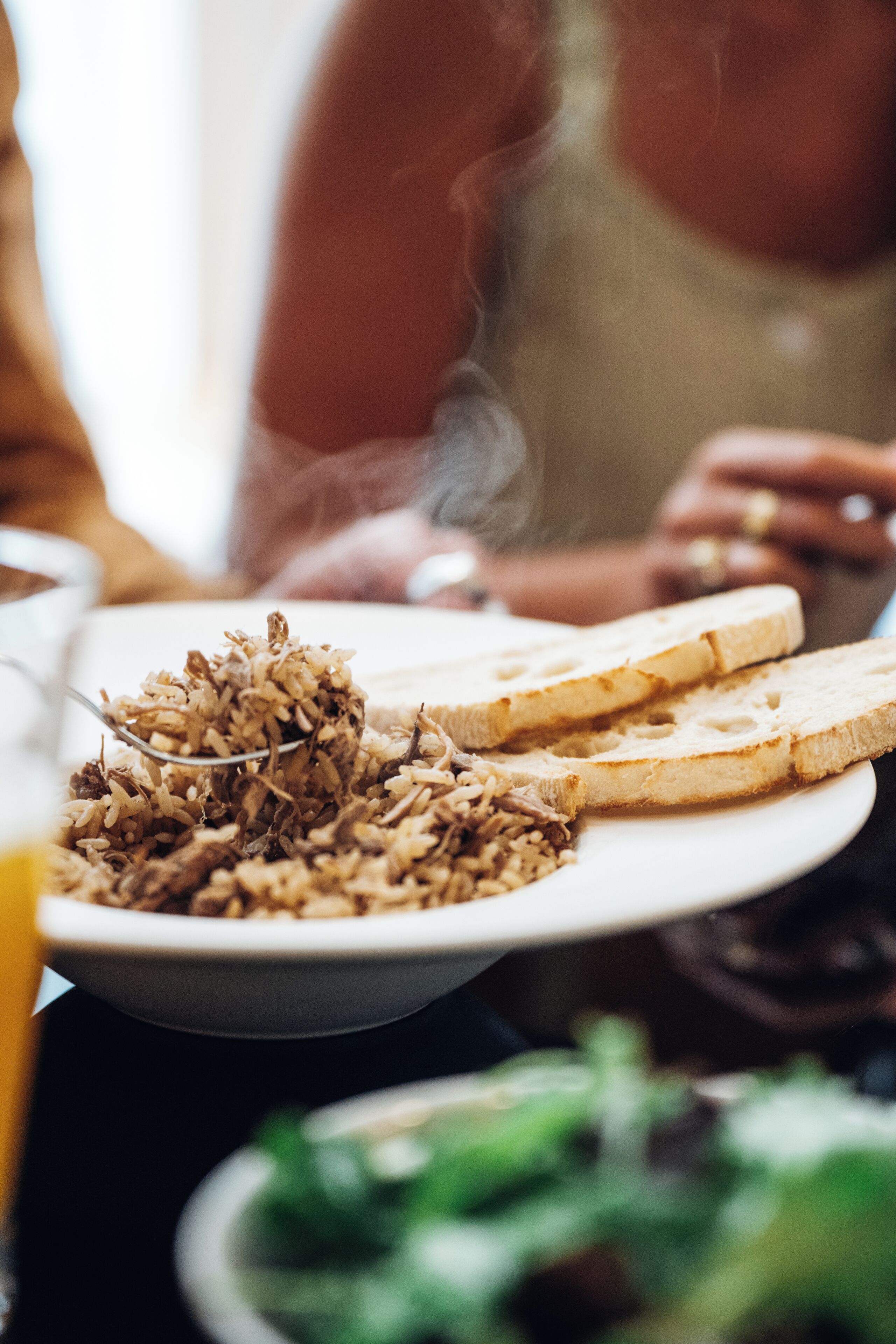 A plate of food with a bowl of rice and two slices of bread.