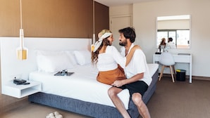 Una habitación de hotel moderna con una cama grande, un escritorio y un espejo.