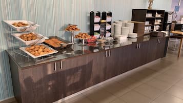 A buffet setup with various food items and a beverage station.