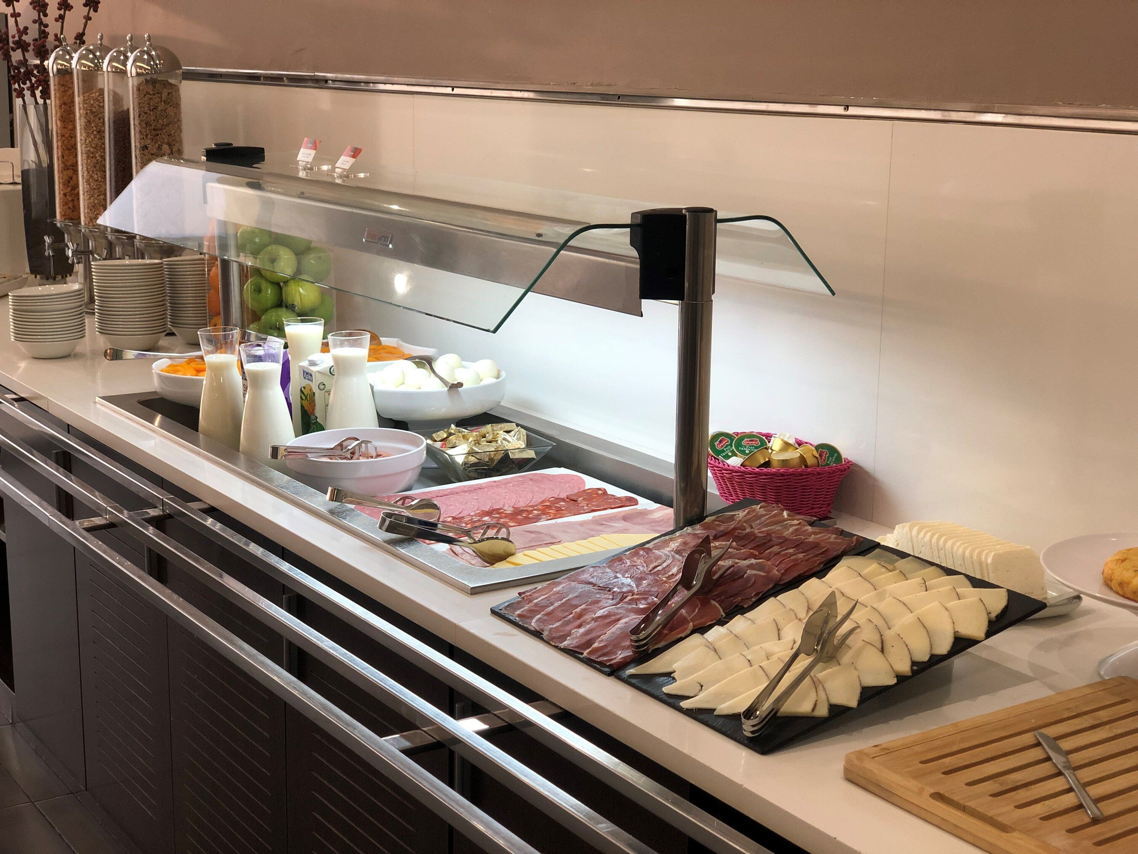 Een buffet met diverse soorten eten, zoals vlees, kaas en fruit.