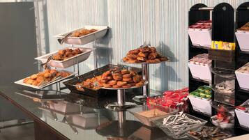 A buffet table with various food items and trays.