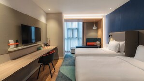 A modern hotel room with a flat-screen TV, a desk with a chair, two beds, and a large window with curtains. - Holiday Inn Express Tianjin Dongli by IHG (Tianjin)