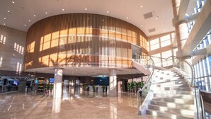 A spacious lobby with a central atrium, a staircase, and a reception desk. - Holiday Inn Express Tianjin Dongli by IHG (Tianjin)