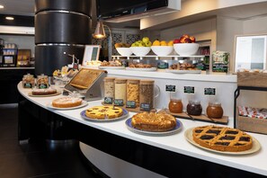 A bakery counter with various baked goods and jars of spreads.