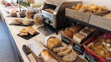 Mostrador de panadería con diferentes panes y pasteles.