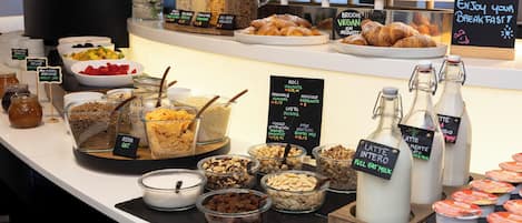 Un bufé de desayuno con diversas opciones de comida y bebidas.