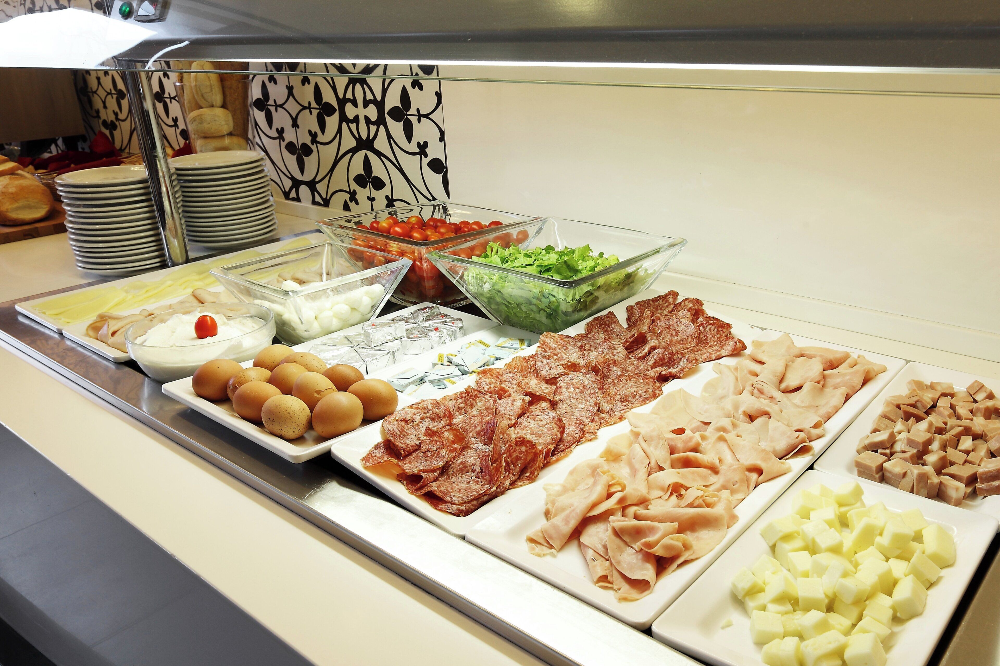 Un buffet con diversi piatti, tra cui uova, carni e insalate.
