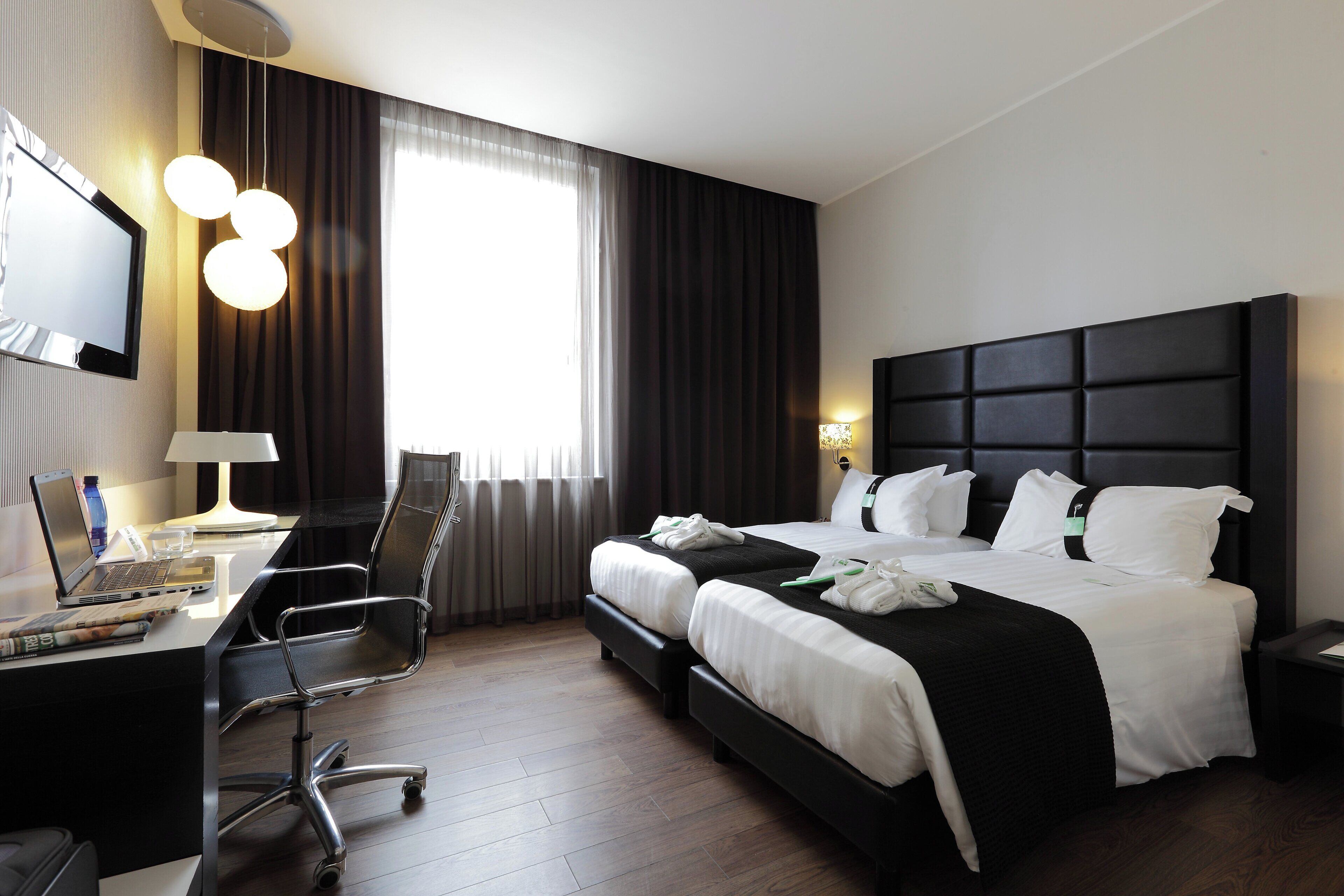 Une chambre d’hôtel équipée d’un lit, d’un bureau, d’une chaise et d’un téléviseur.