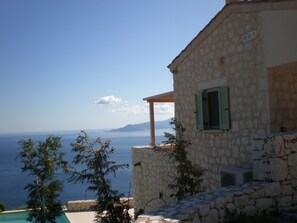 A stone building with a view of the sea and mountains. - Urania Luxury Villas (Lefkada)