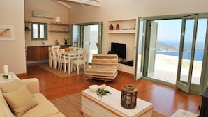 Un amplio salón con una mesa de comedor, un sofá y una chimenea.