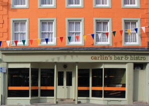 A building with a sign reading "carlin's bar & bistro" and a row of windows with curtains. - Allerdale Court Hotel (Cockermouth)