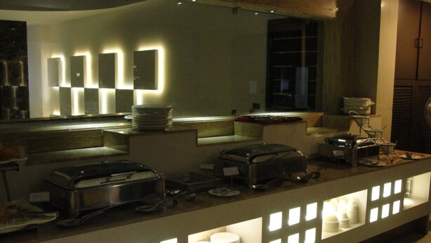 A buffet setup with multiple serving stations, a variety of dishes, and a modern design with illuminated panels. - Hotel Chanchal Deluxe (New Delhi)