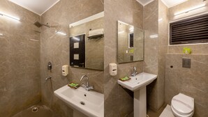 A modern bathroom with a shower, two sinks, a toilet, and a mirror. - Hotel Chanchal Continental (New Delhi)