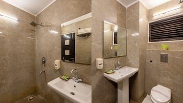 Habitación Deluxe, 1 cama matrimonial | Baño | Regadera, amenidades de baño gratuitas, pantuflas