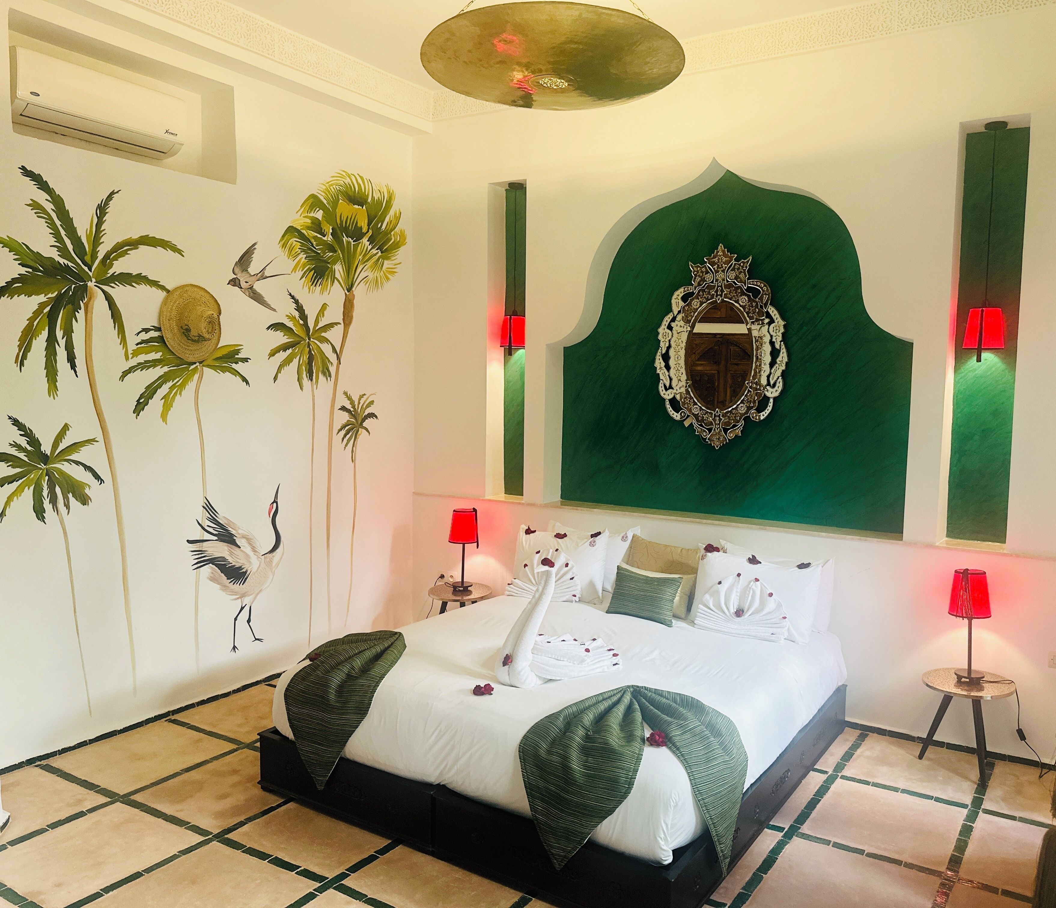 A well-appointed hotel room with a large bed, decorative wall art, and a green accent wall.