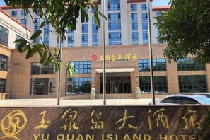 A hotel entrance with a sign in Chinese characters, a modern building facade, and a clear sky. - Yuquan Island Hotel (Nanchang)