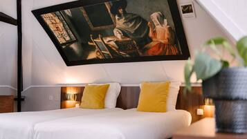 Un dormitorio moderno con una cama, dos mesitas de noche y un cuadro grande sobre la cama.